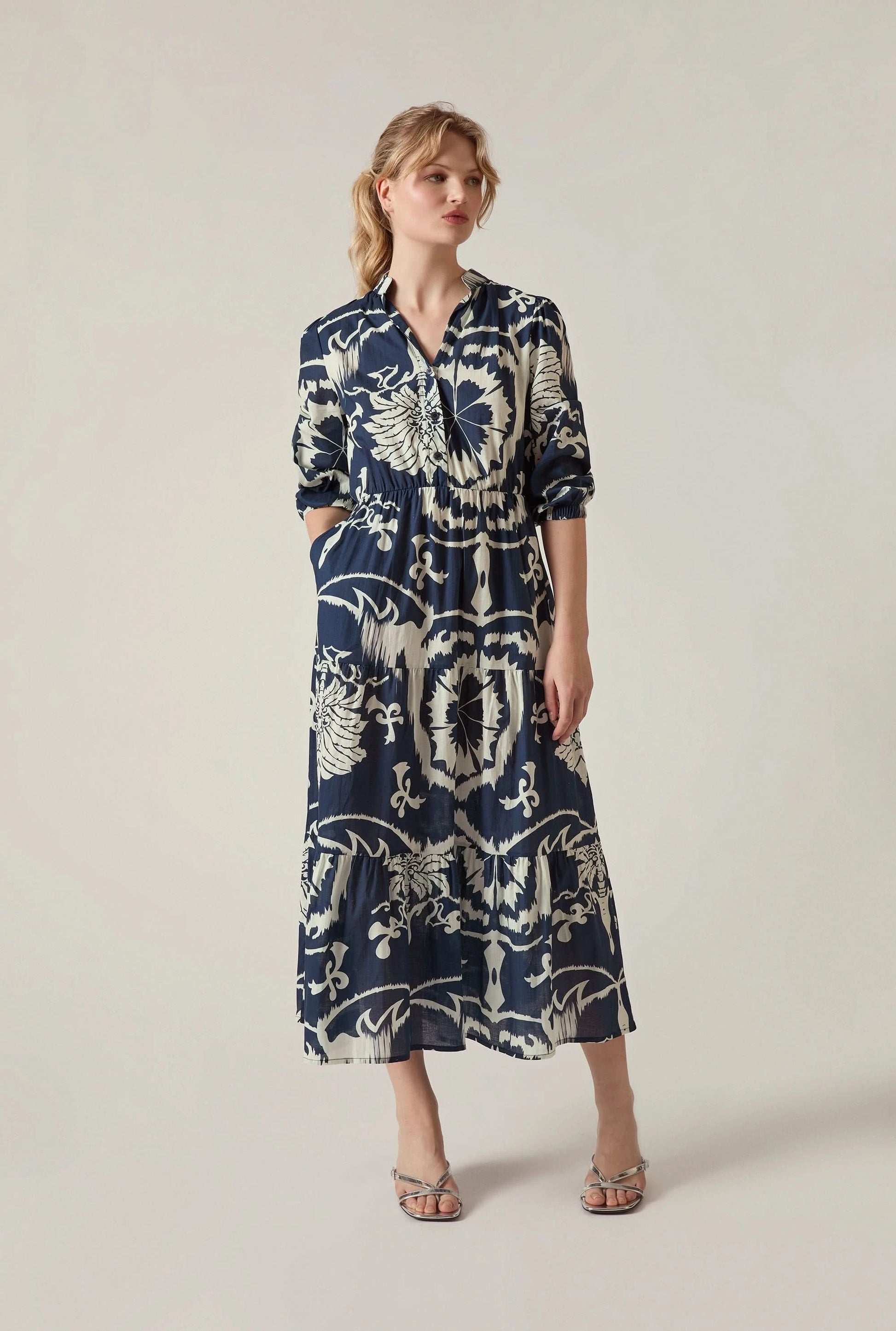 Model wearing the Navy Ornamental Print Tiered Midi Dress by James Lakeland on a neutral beige background