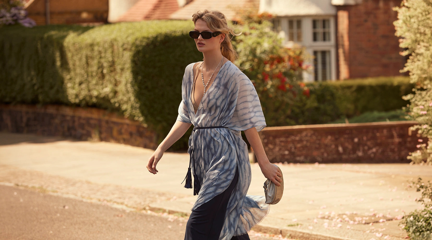 Woman wearing the Blue Shibori Print Kaftan by James Lakeland on a quiet summer street